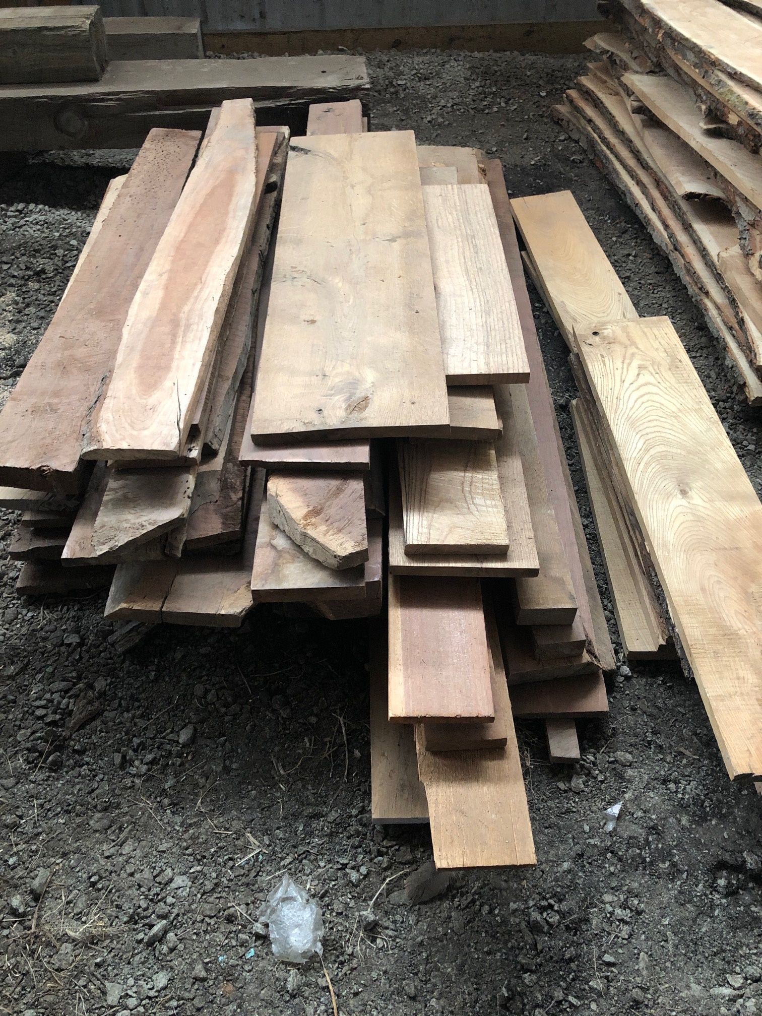 A pile of wood is sitting on top of a pile of gravel.