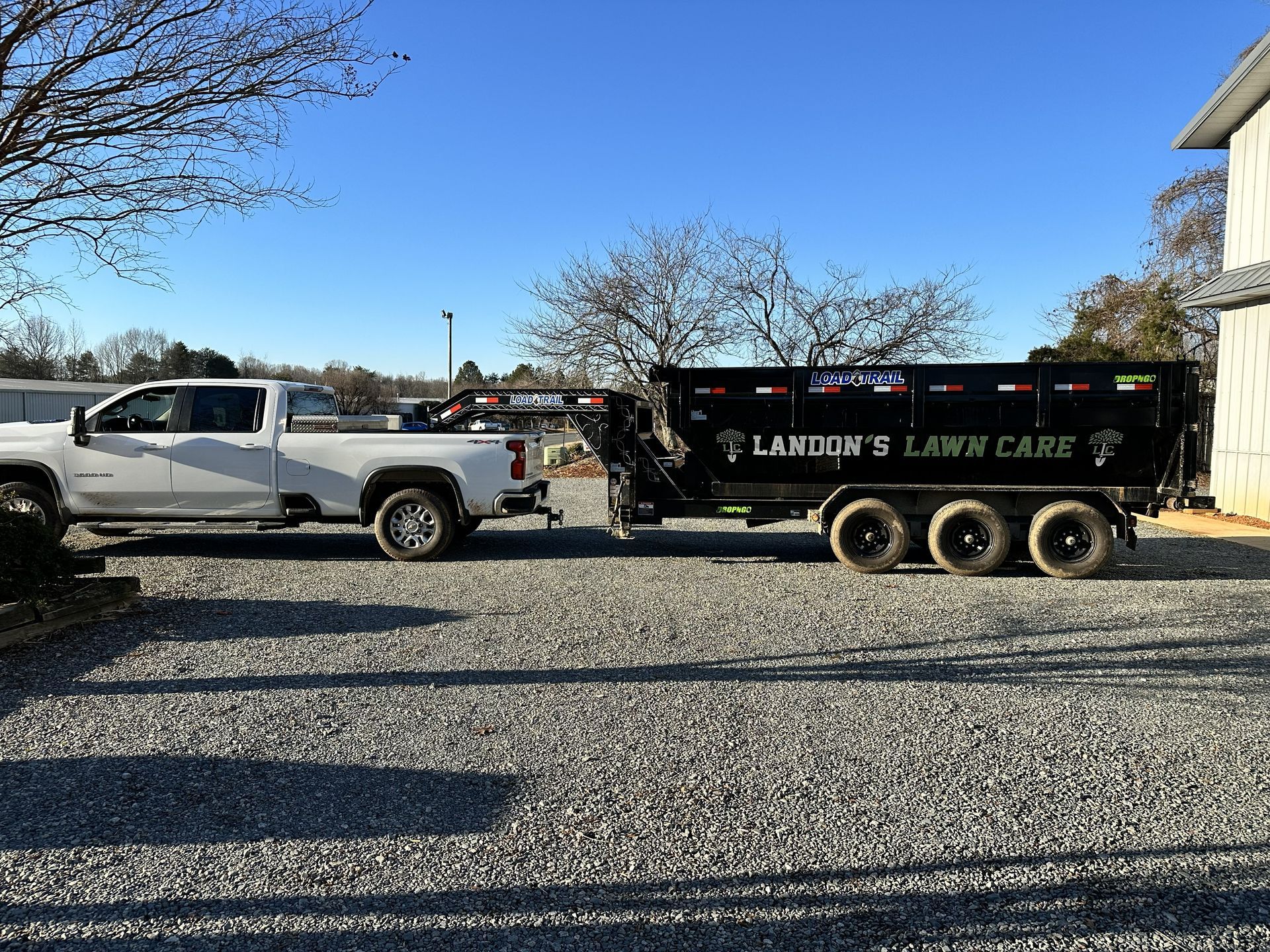 White pickup truck towing a black trailer labeled 