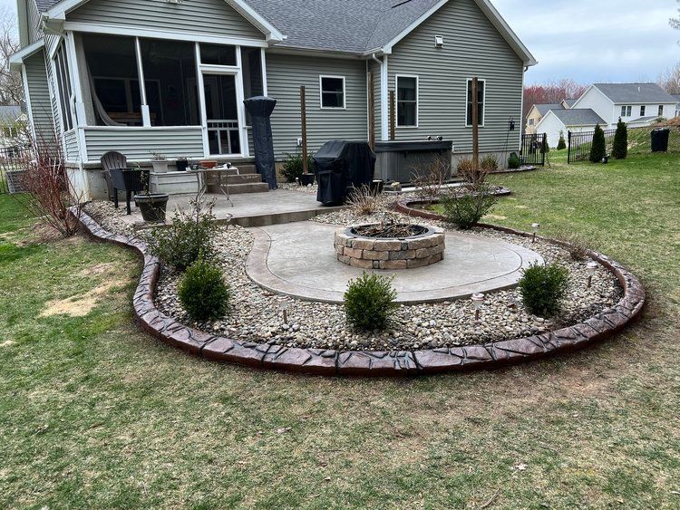 there is a fire pit in the middle of the yard in front of a house