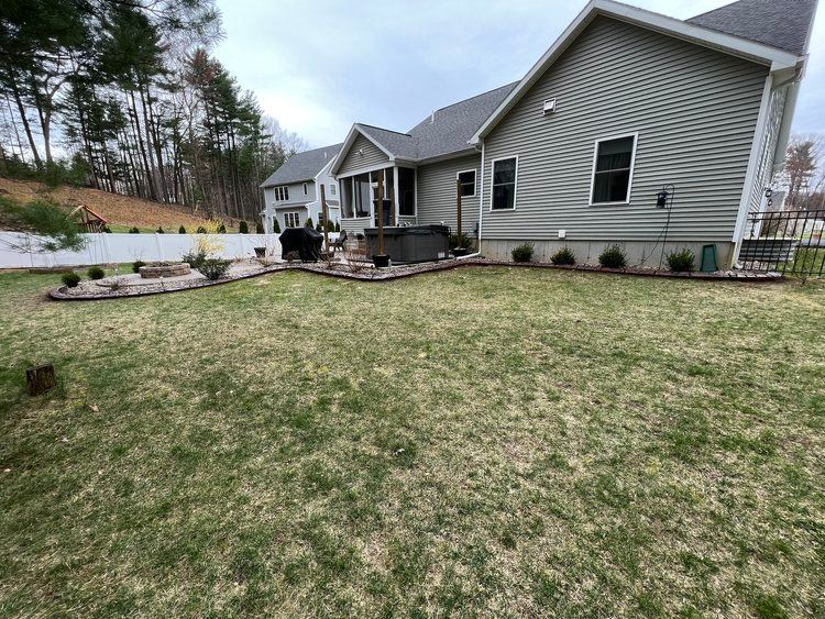 a large lawn in front of a house with a hot tub in the backyard