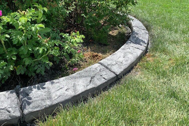 a concrete curb is sitting in the middle of a lush green lawn