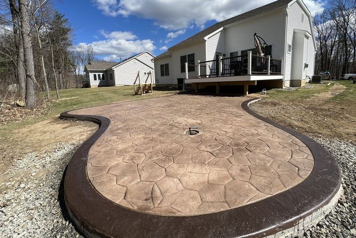a concrete walkway leading to a house with a deck .