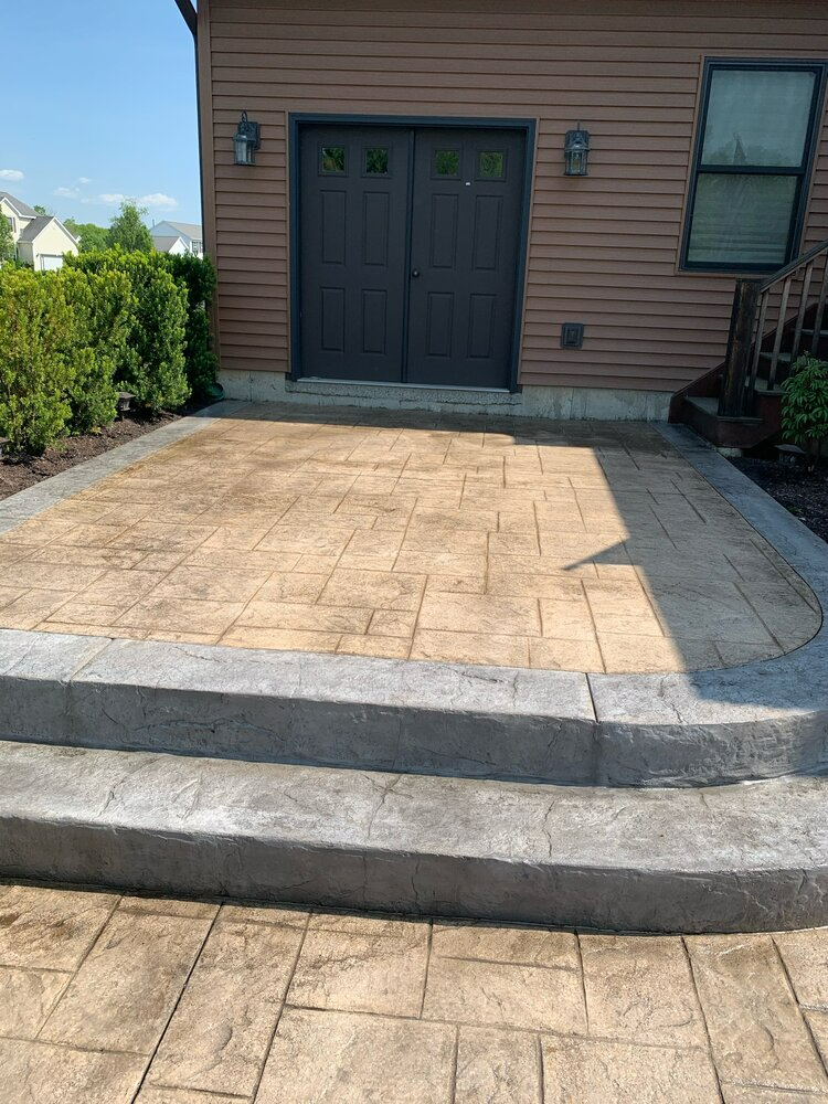 a patio with stairs leading up to a garage door .