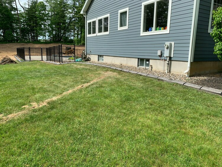 a blue house with a large lawn in front of it .