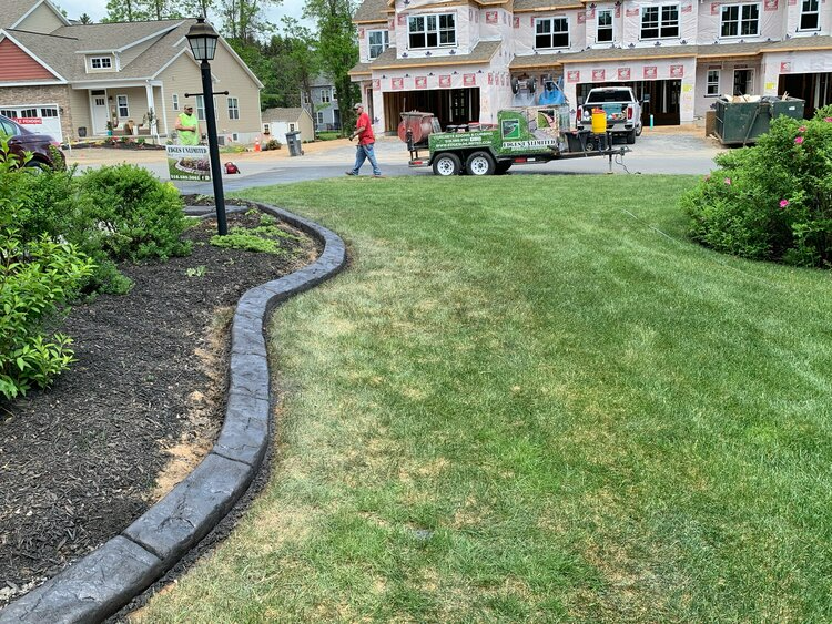 a concrete curb is being installed in front of a house .