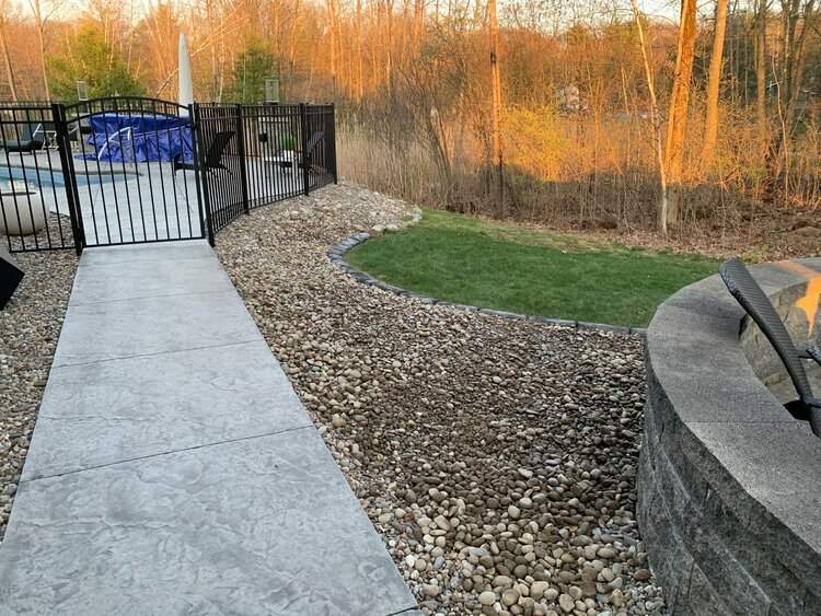 a walkway leading to a pool and a fire pit .