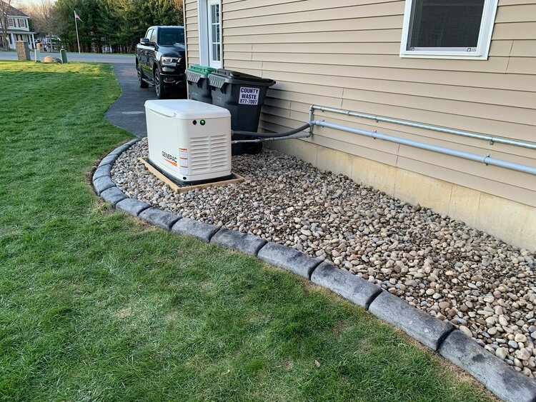 a generator is sitting on the side of a house .