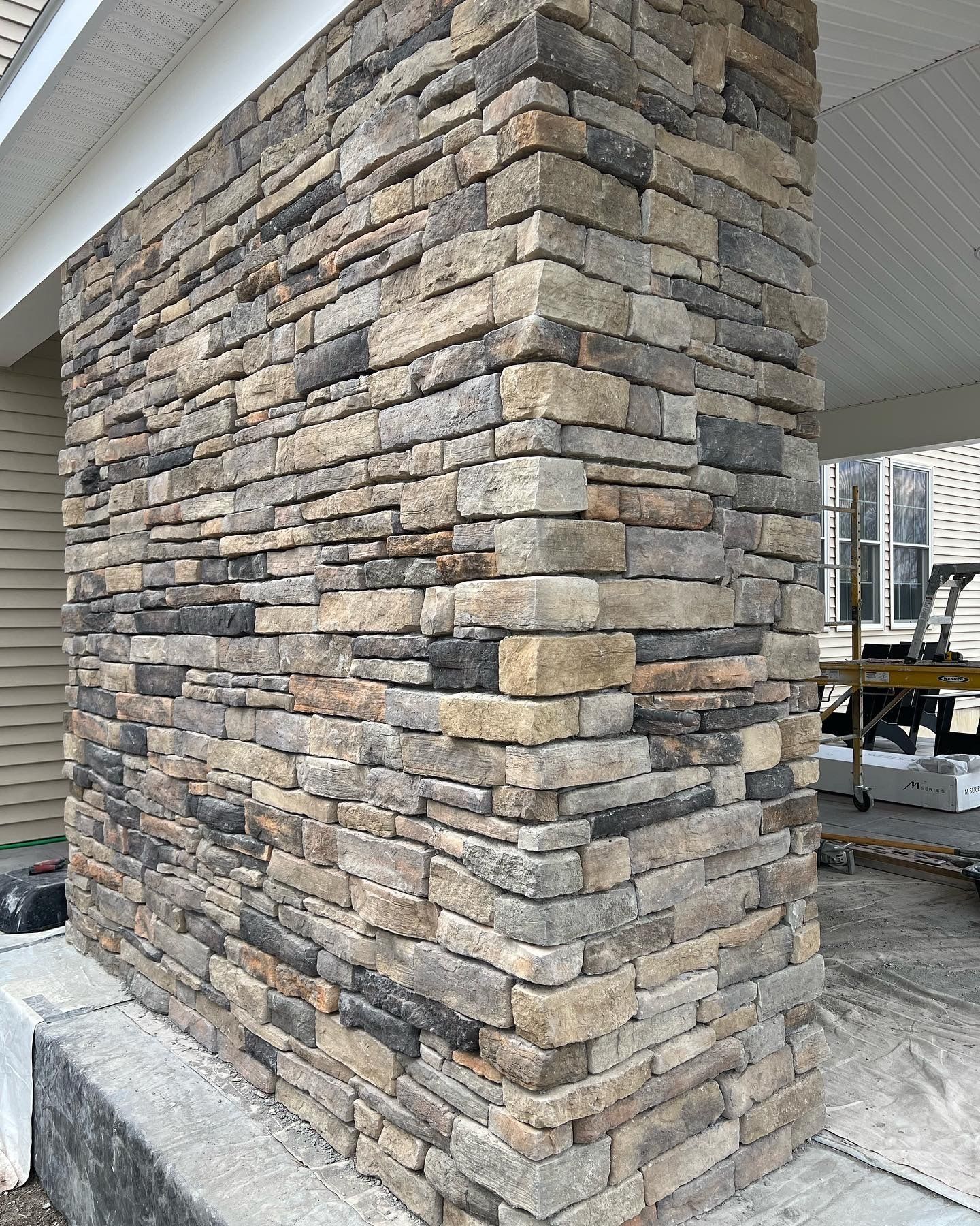 a stone wall is being built on the side of a house