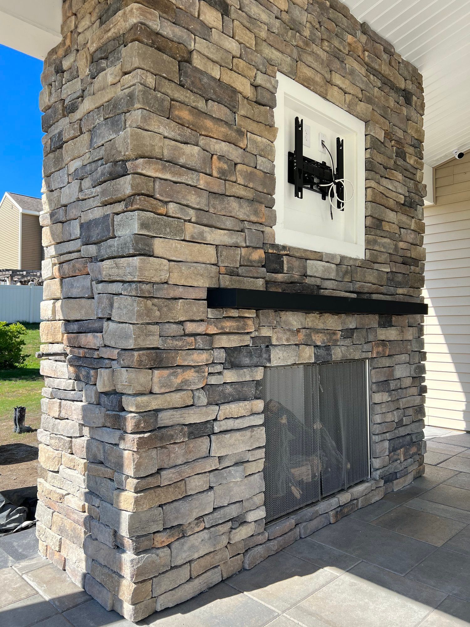 a stone fireplace with a flat-screen tv mounted on the wall