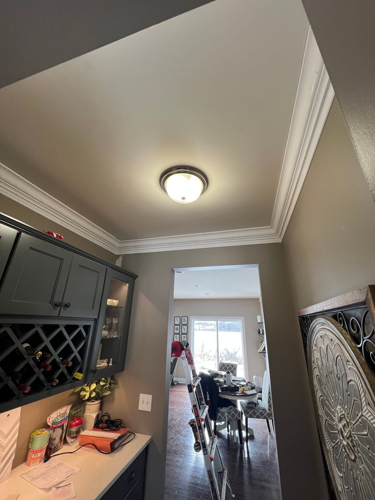 a hallway leading to a dining room with a light on the ceiling