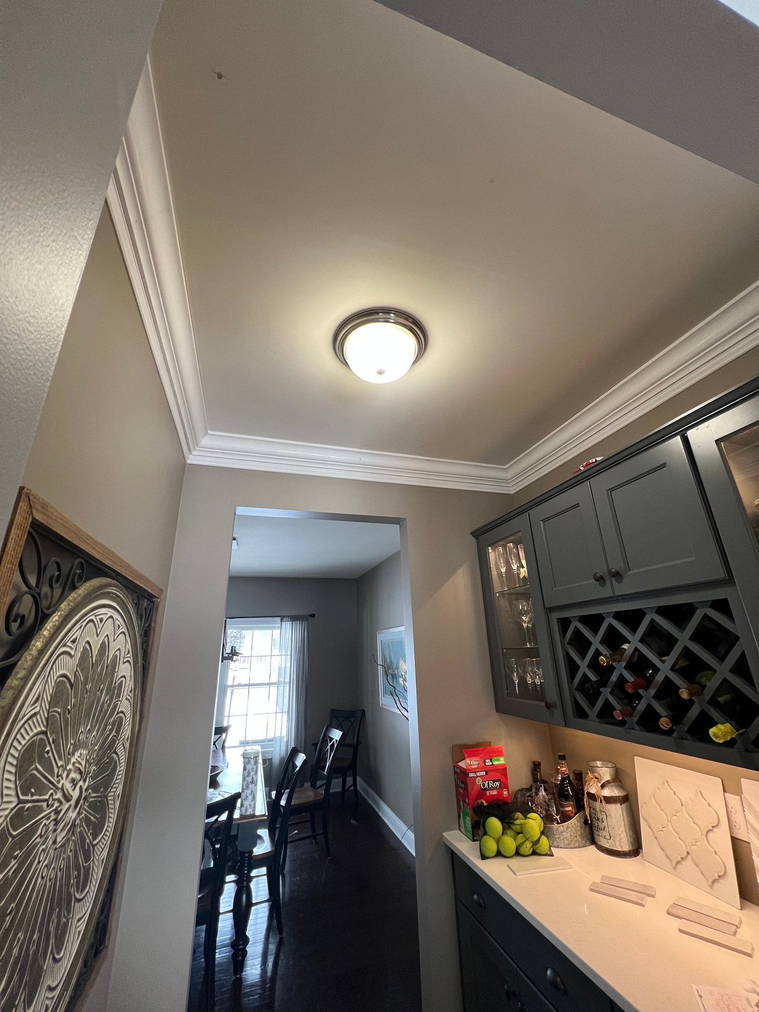 a kitchen with a wine rack and a dining room in the background