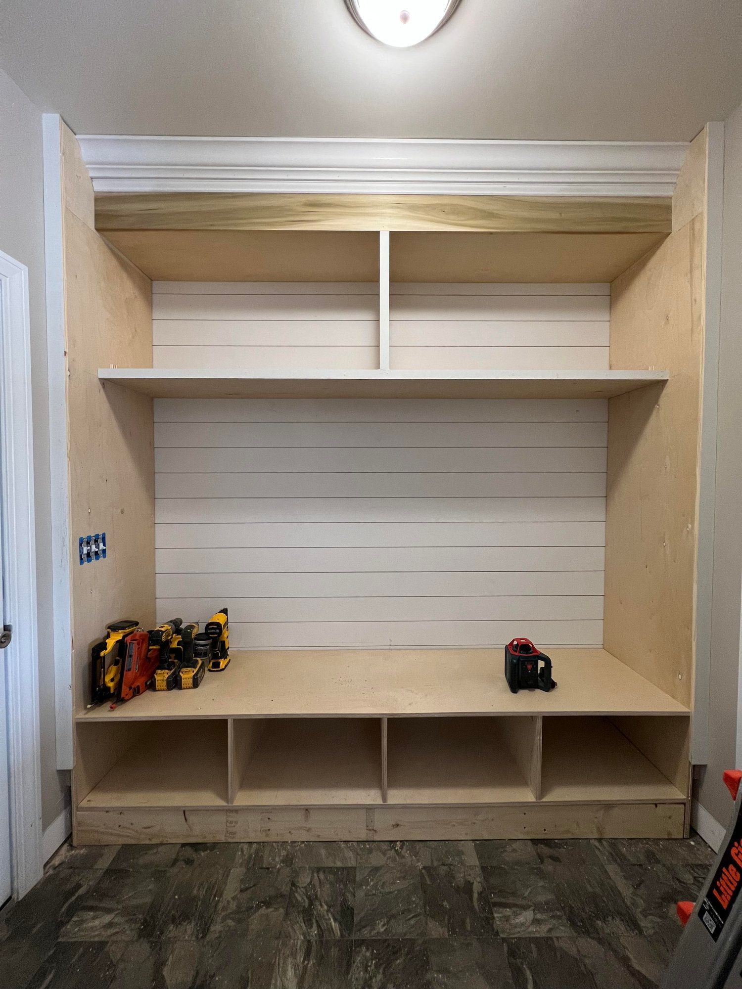 a room with a bench and shelves in it