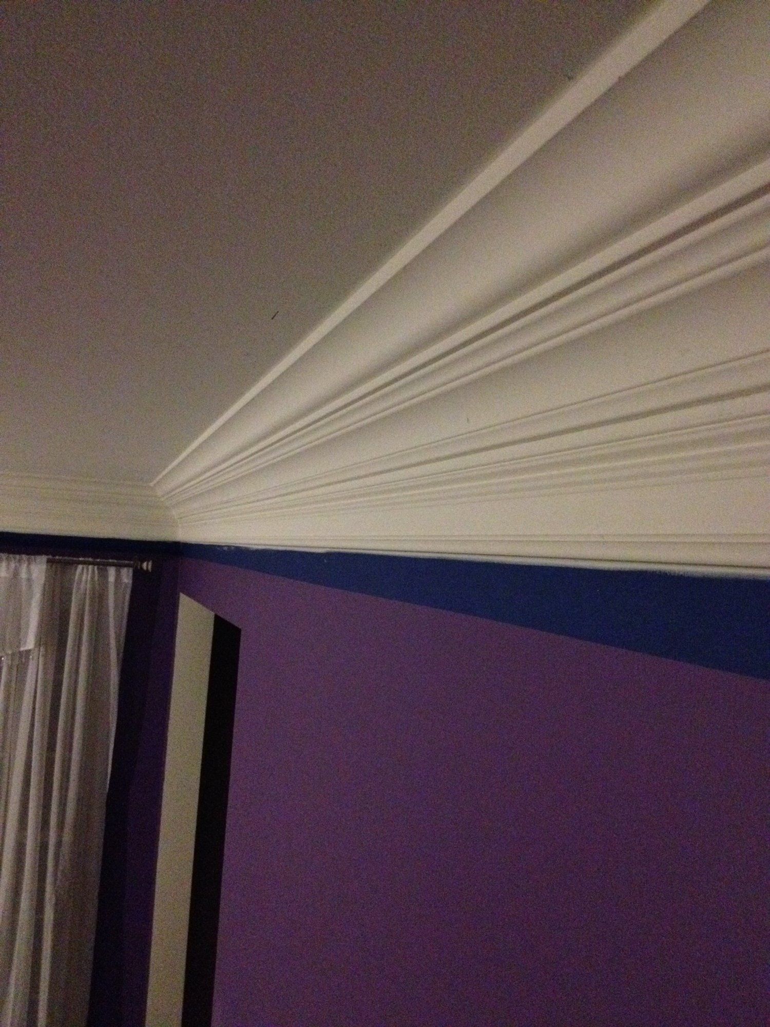 a room with purple walls and white trim on the ceiling