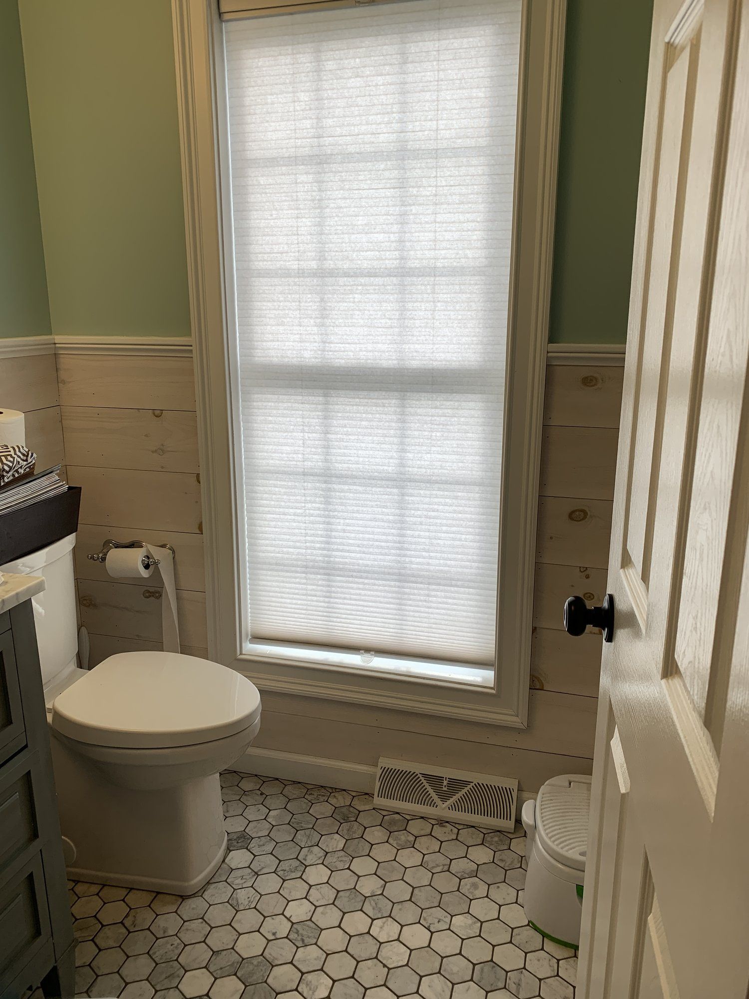 a bathroom with a toilet, sink, and window