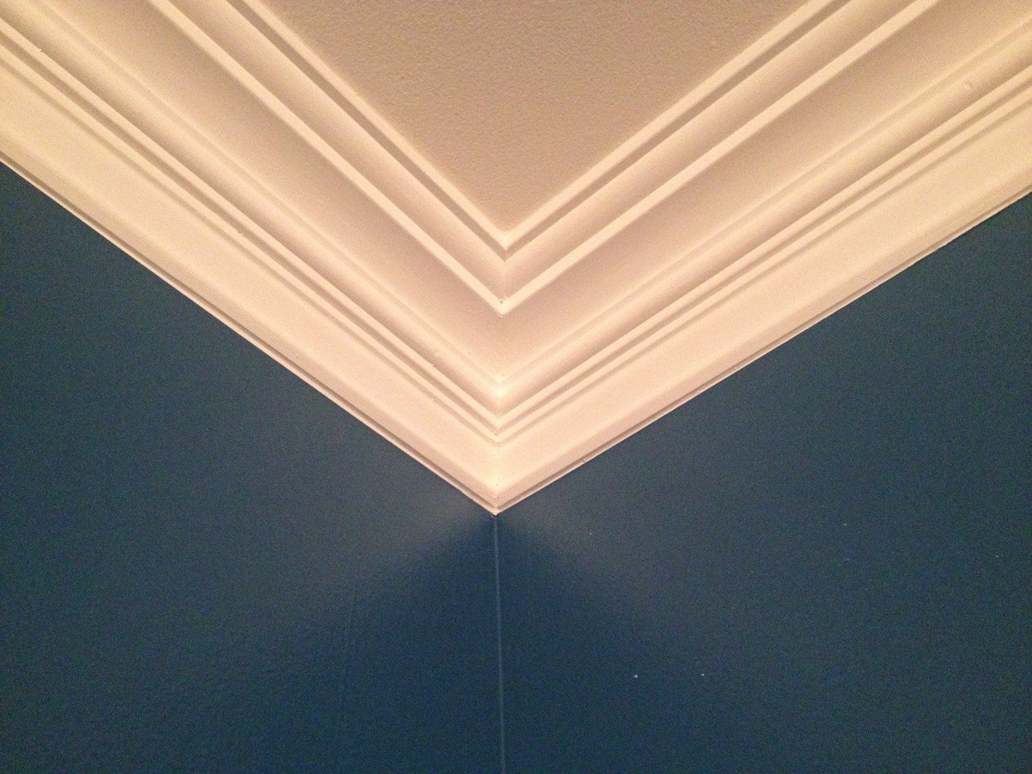 a corner of a room with blue walls and white trim