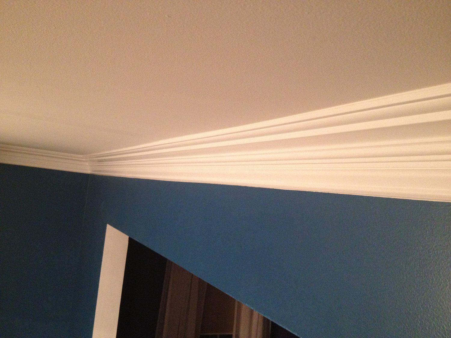 a room with blue walls and white trim on the ceiling