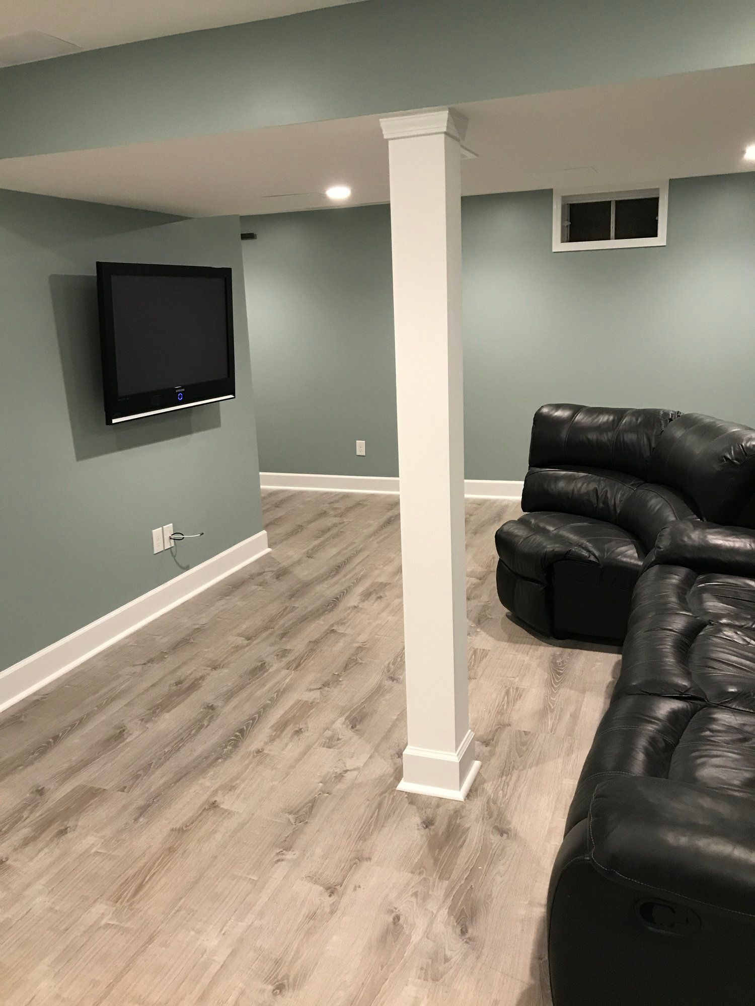 a living room with a couch and a television on the wall