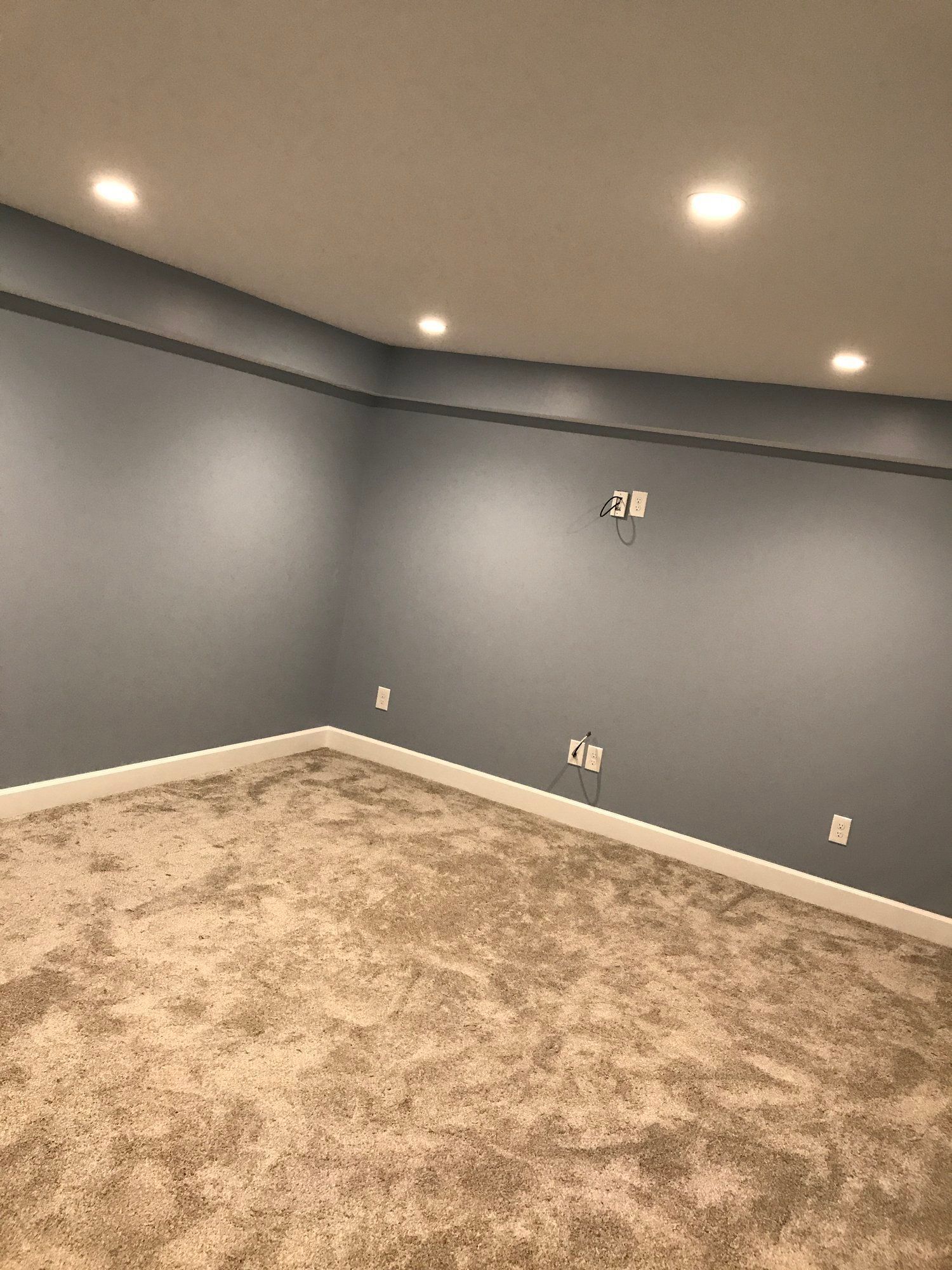 an empty basement with a carpeted floor and gray walls