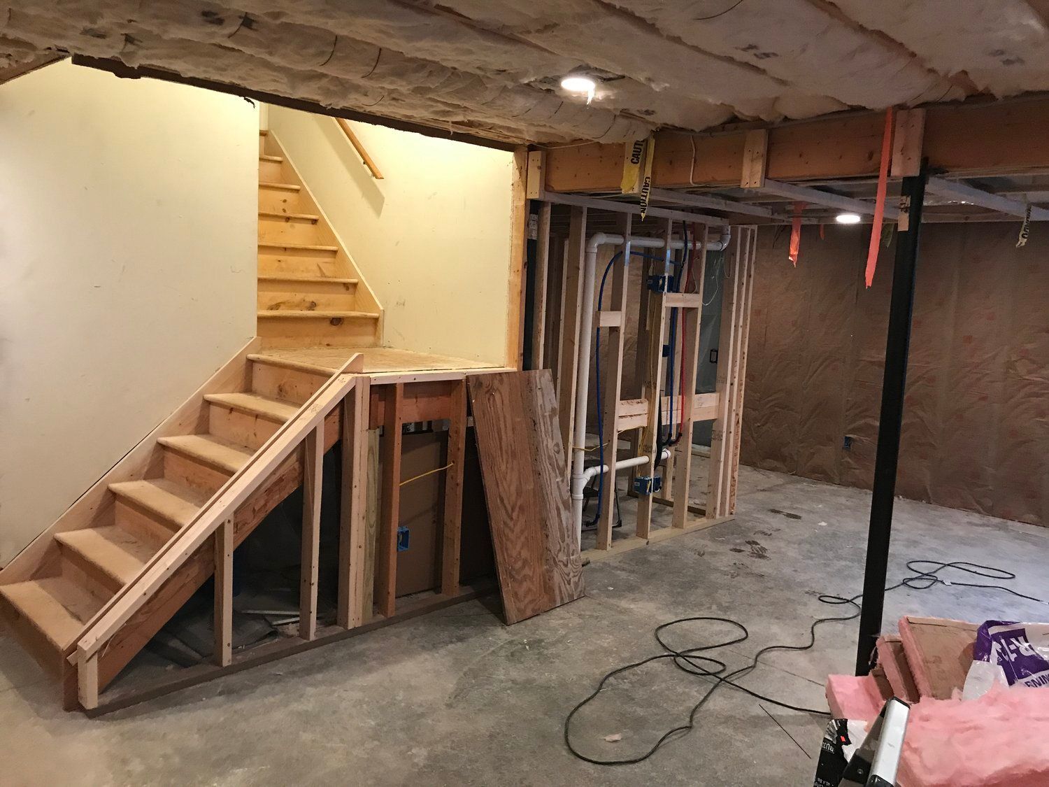 a basement under construction with stairs and a ladder