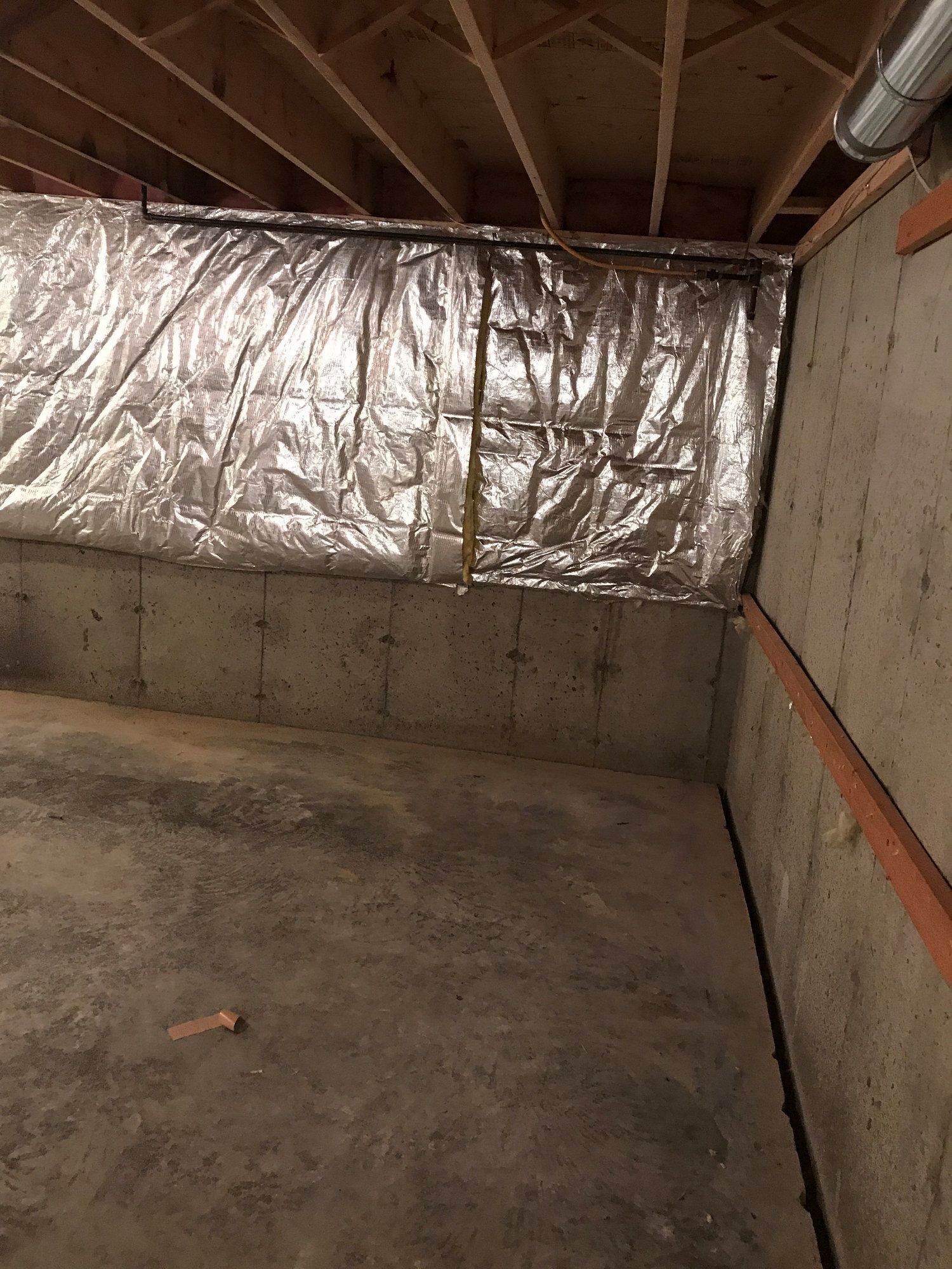 a basement with aluminum insulation on the walls and ceiling