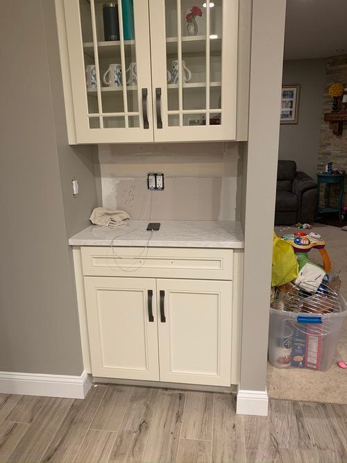 a kitchen with white cabinets and a marble counter top