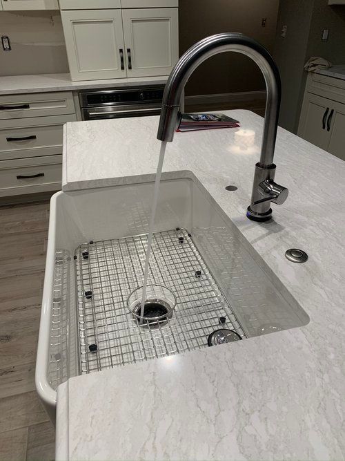 a kitchen sink with water running from the faucet