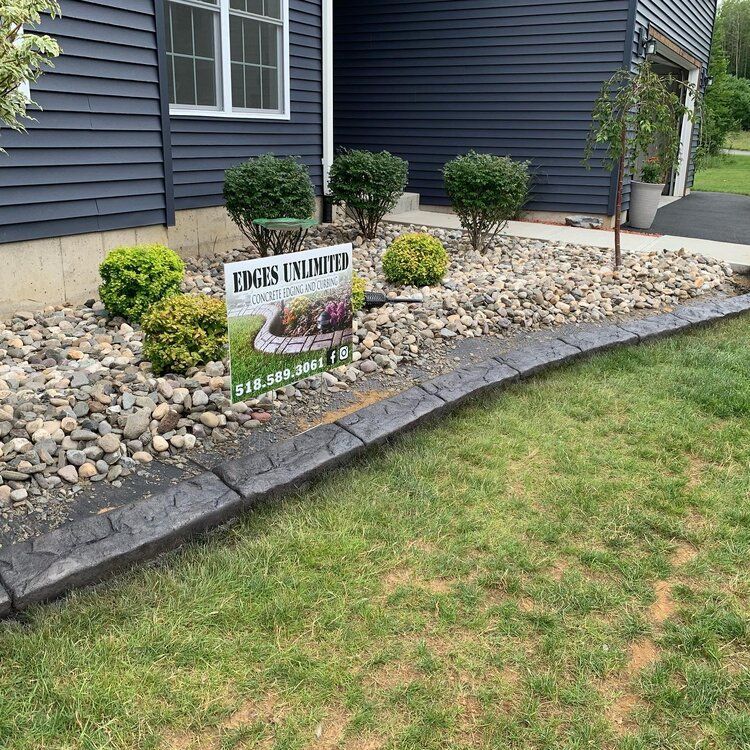 a sign is sitting in the grass in front of a house