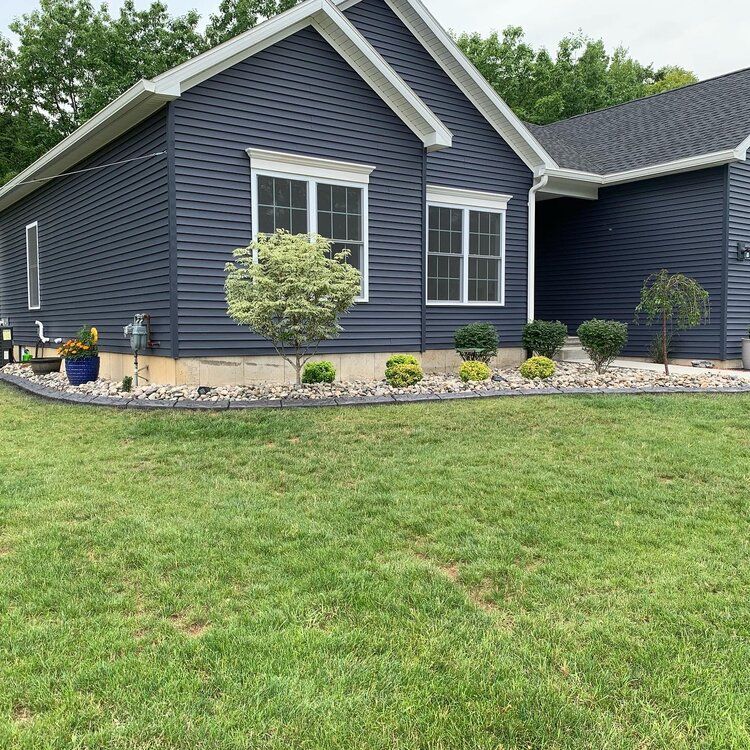 a blue house with a lush green lawn in front of it