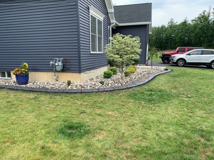 a house with a lawn in front of it and two cars parked in front of it