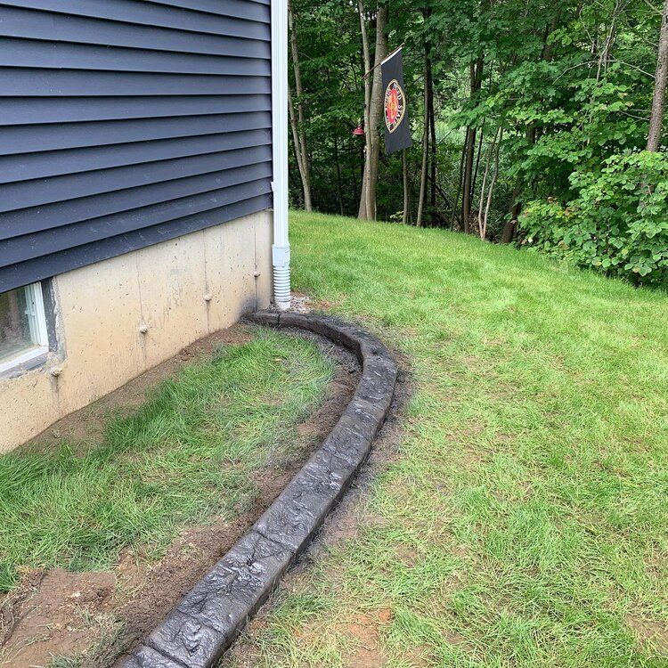 a concrete curb is being installed in front of a house