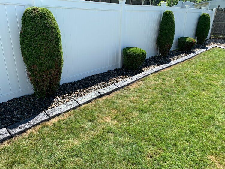 a white fence surrounds a lush green lawn