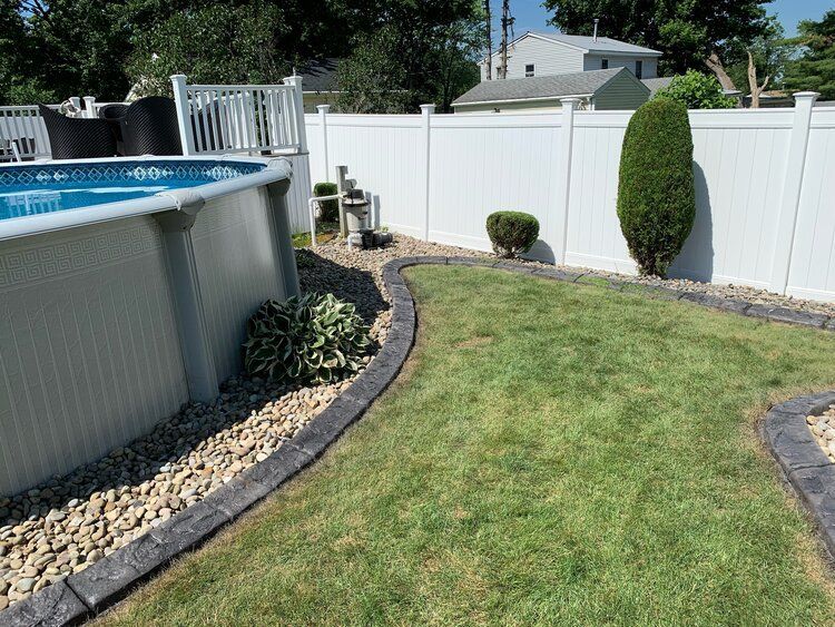 a white fence surrounds a swimming pool in a backyard