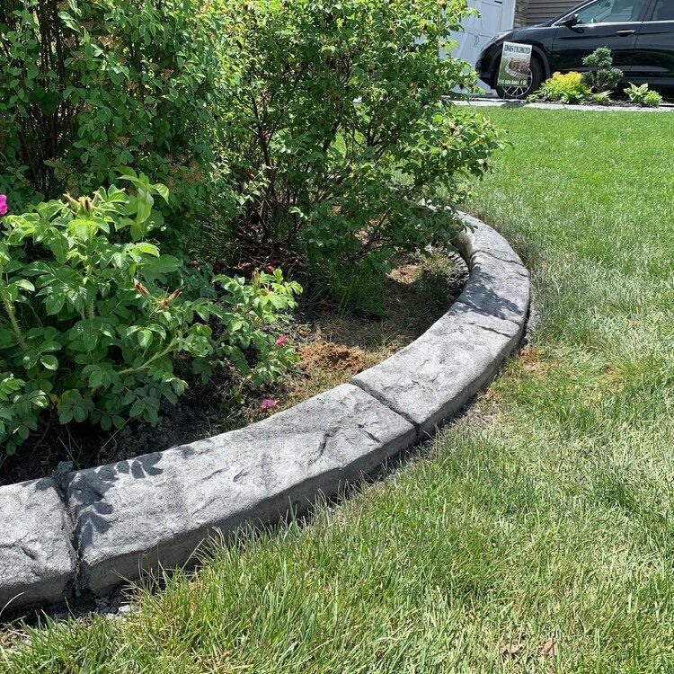 a concrete curb is sitting in the middle of a lush green lawn