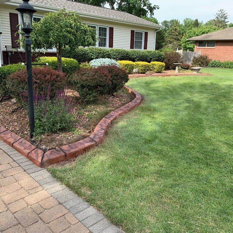 a house with a lush green lawn and a brick walkway