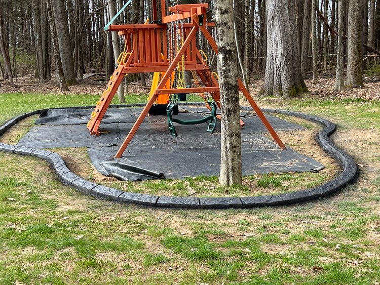 a playground set is sitting in the middle of a lush green field