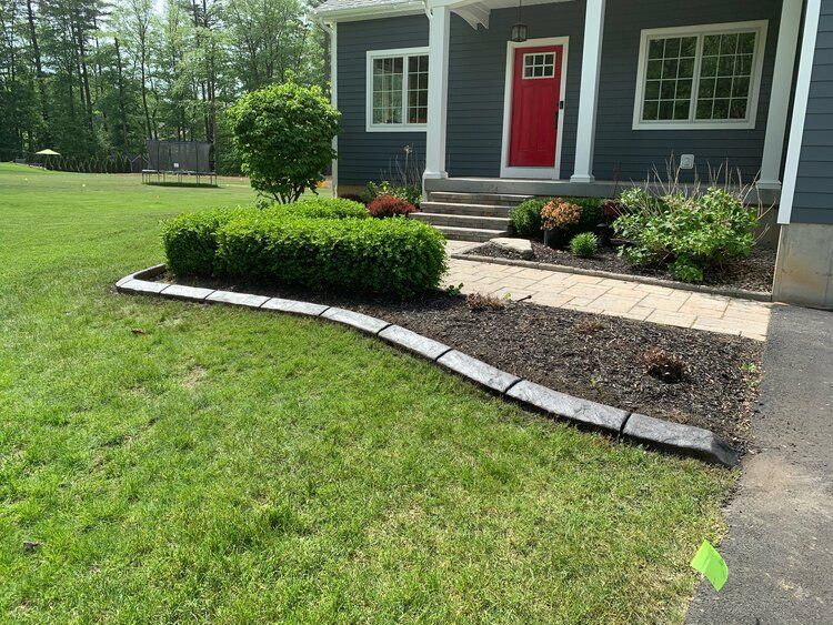 a blue house with a red door and a lush green lawn in front of it