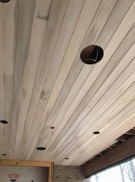 Wood plank ceiling with recessed light openings.