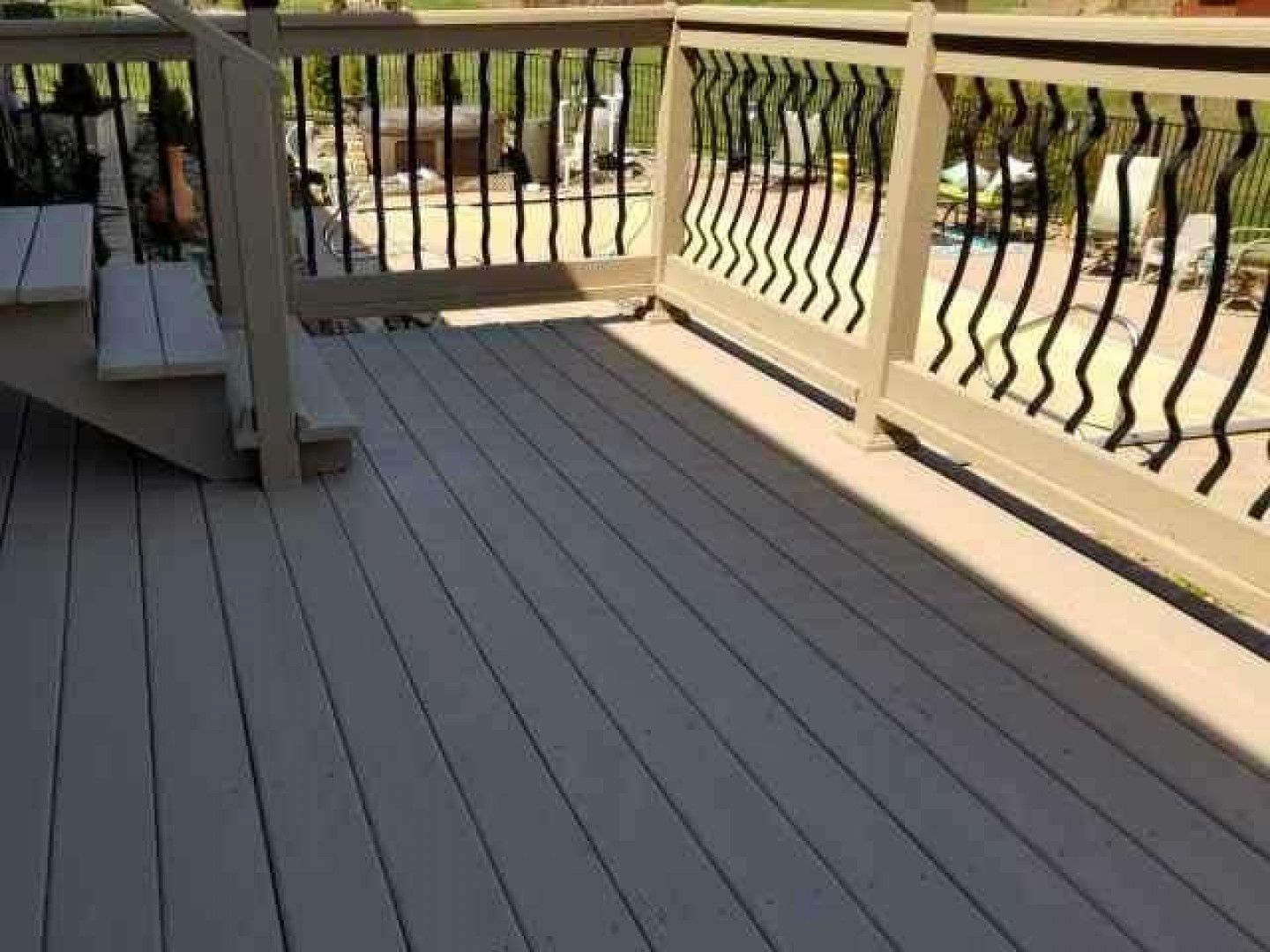 Beige composite deck with black decorative railing.
