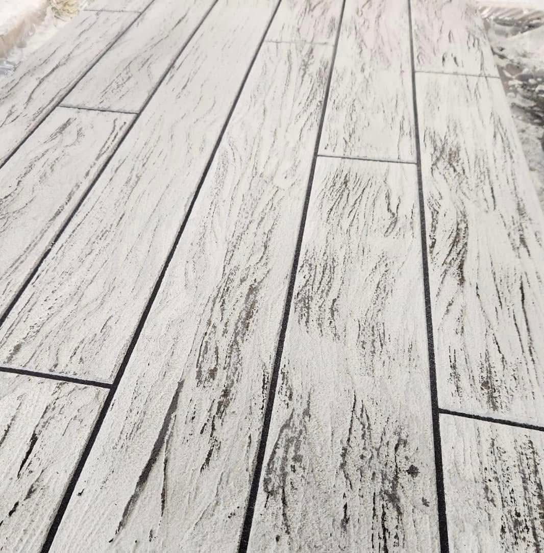 White concrete planks, textured to resemble weathered wood, laid on a surface.