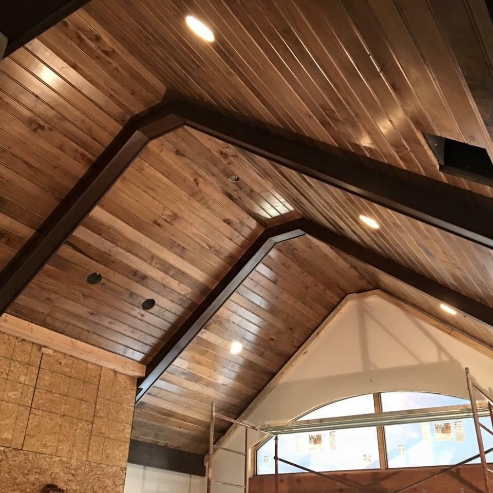 Wooden ceiling with recessed lighting in a room under construction.