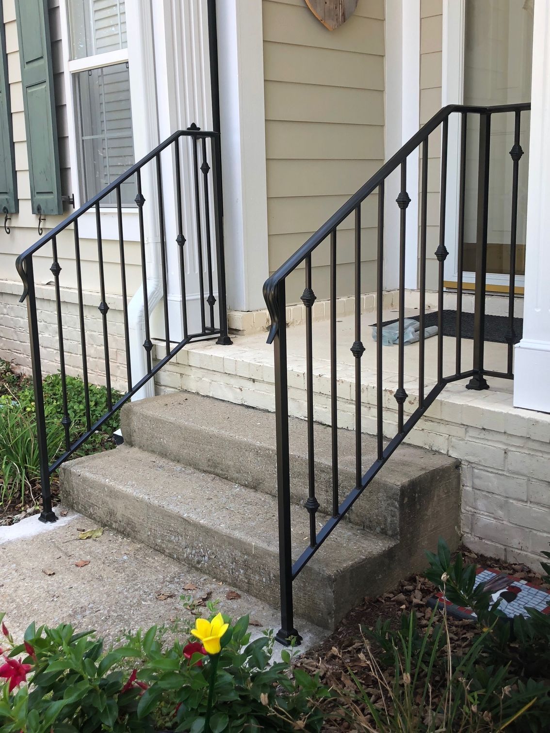 There is a wrought iron railing on the steps of a house.