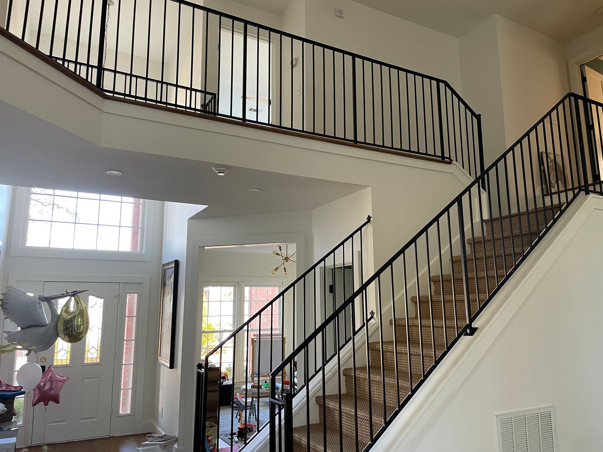 A staircase with a wrought iron railing leading up to the second floor of a house.