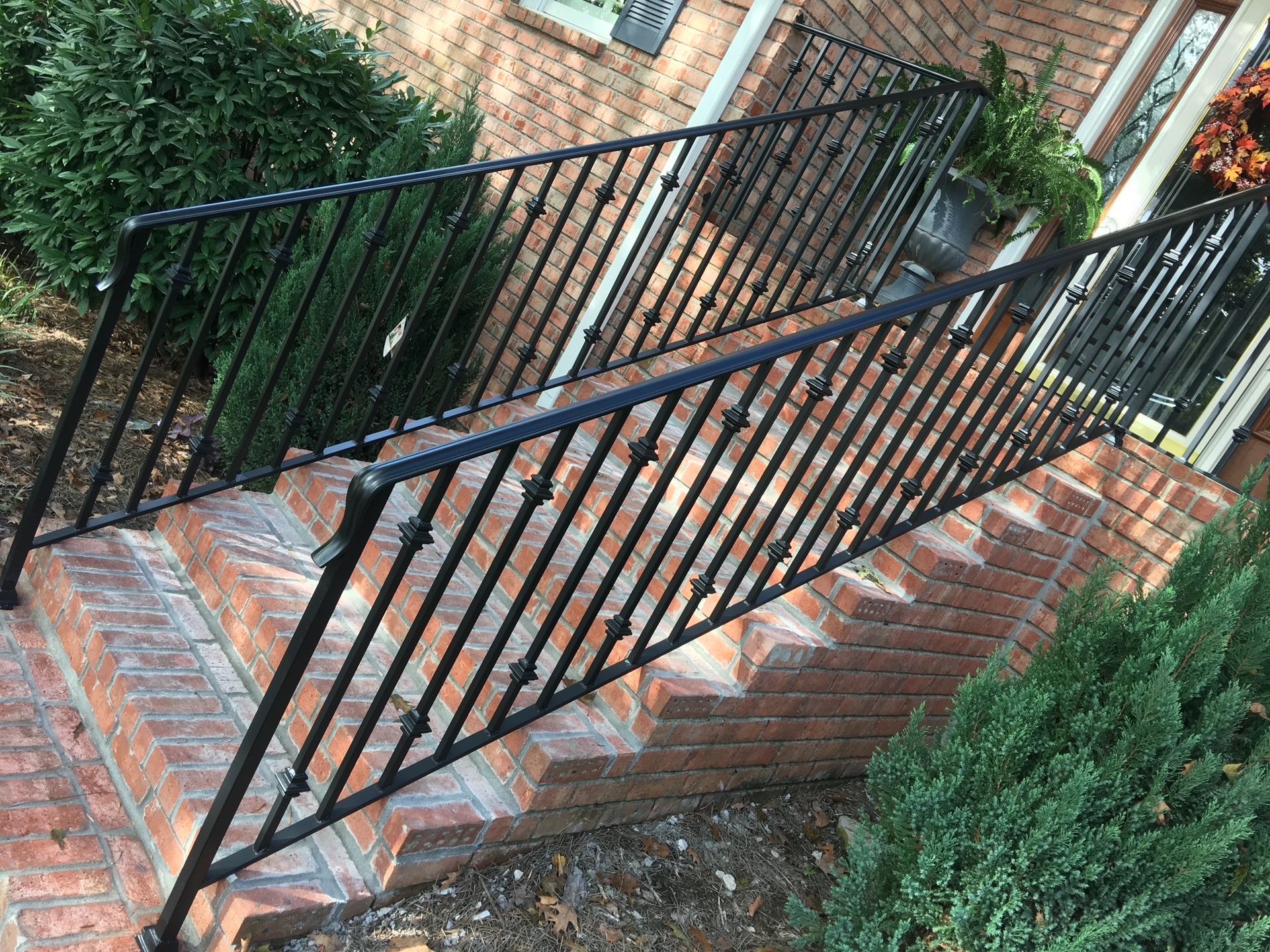 A black wrought iron railing is sitting on top of a set of stairs.