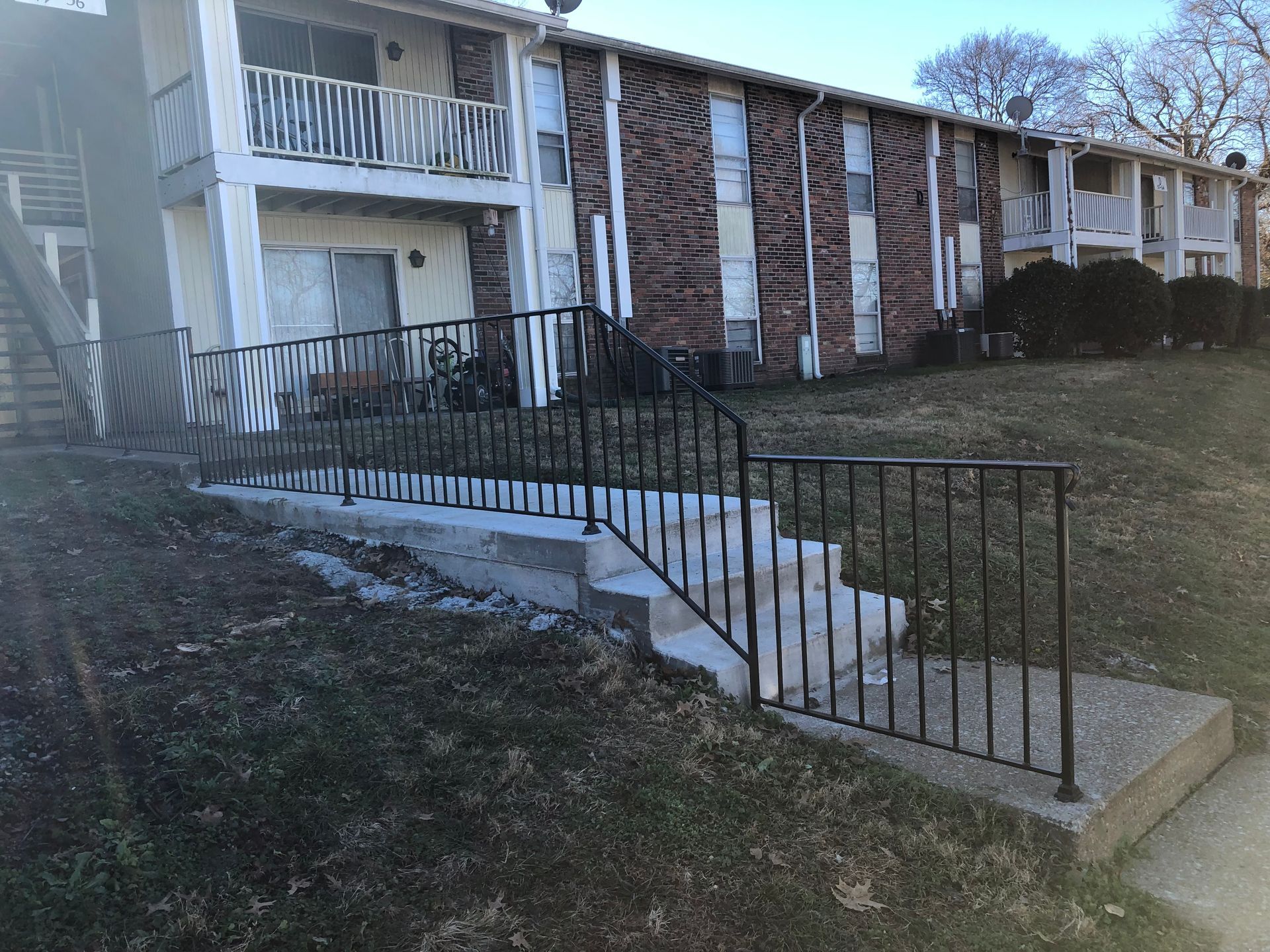 A building with stairs and a railing in front of it.
