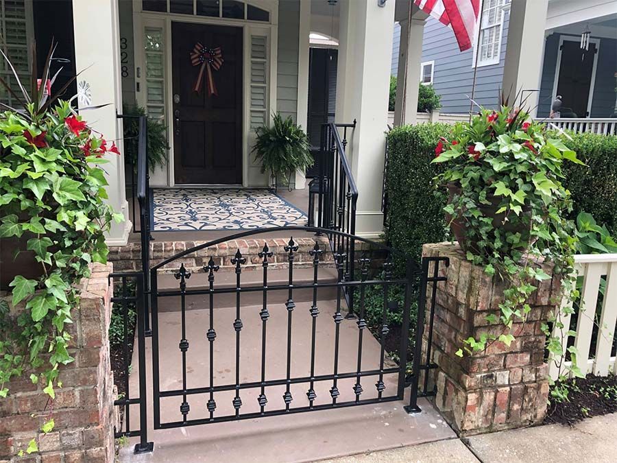 A black wrought iron gate is in front of a house.