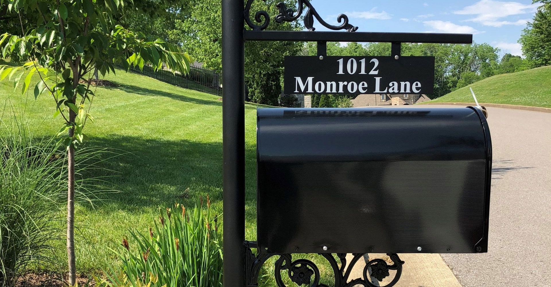 A black mailbox with a sign that says 1012 monroe lane