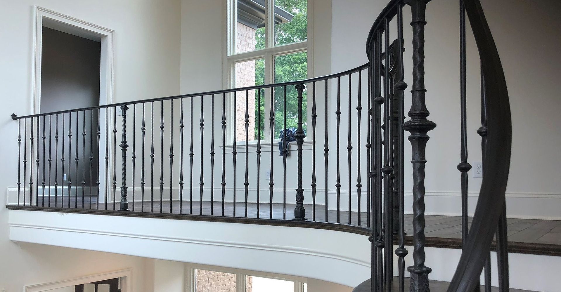 A spiral staircase with a wrought iron railing in a house