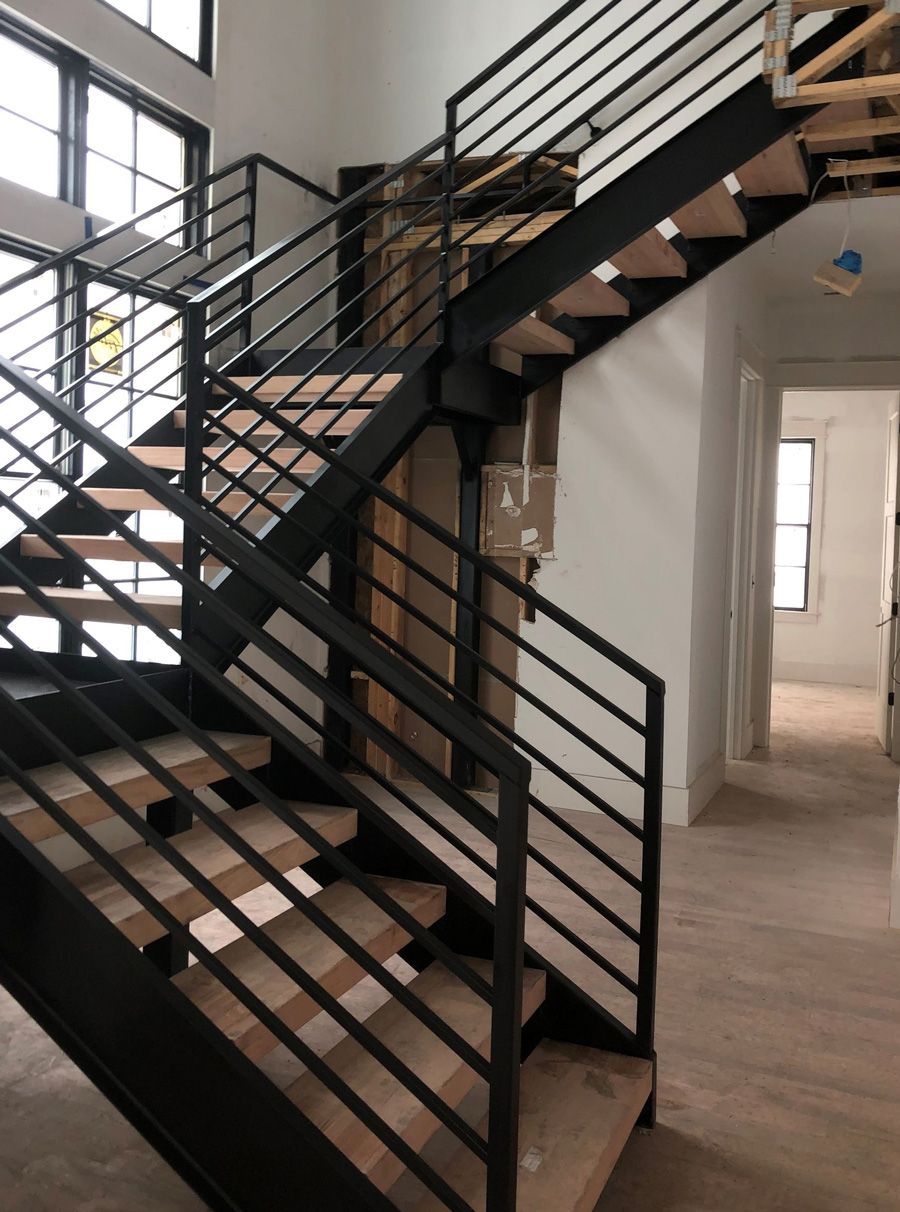 A staircase with a black railing and wooden steps