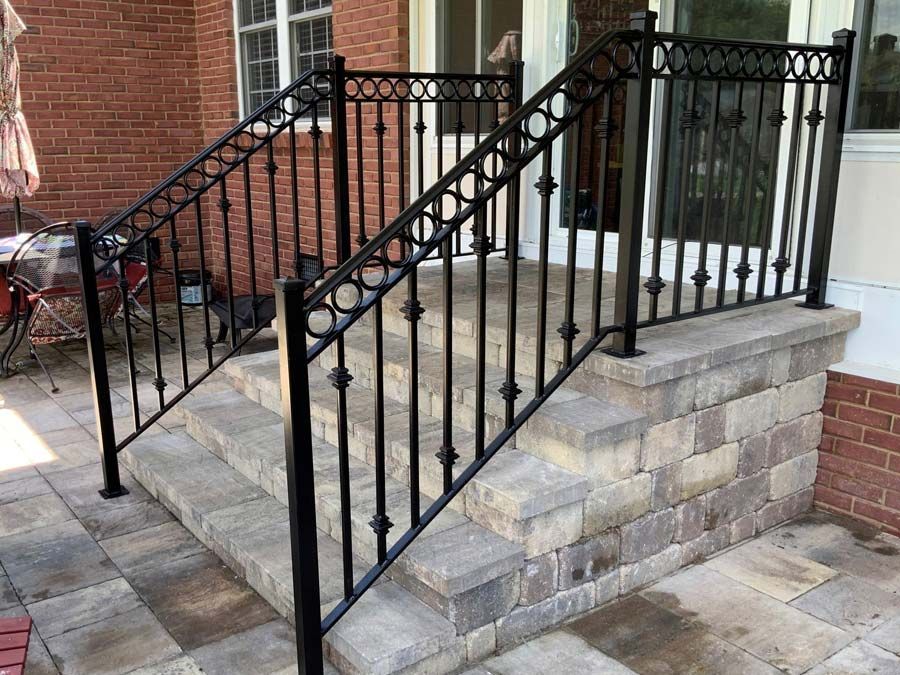 There is a wrought iron railing on the steps of a house.