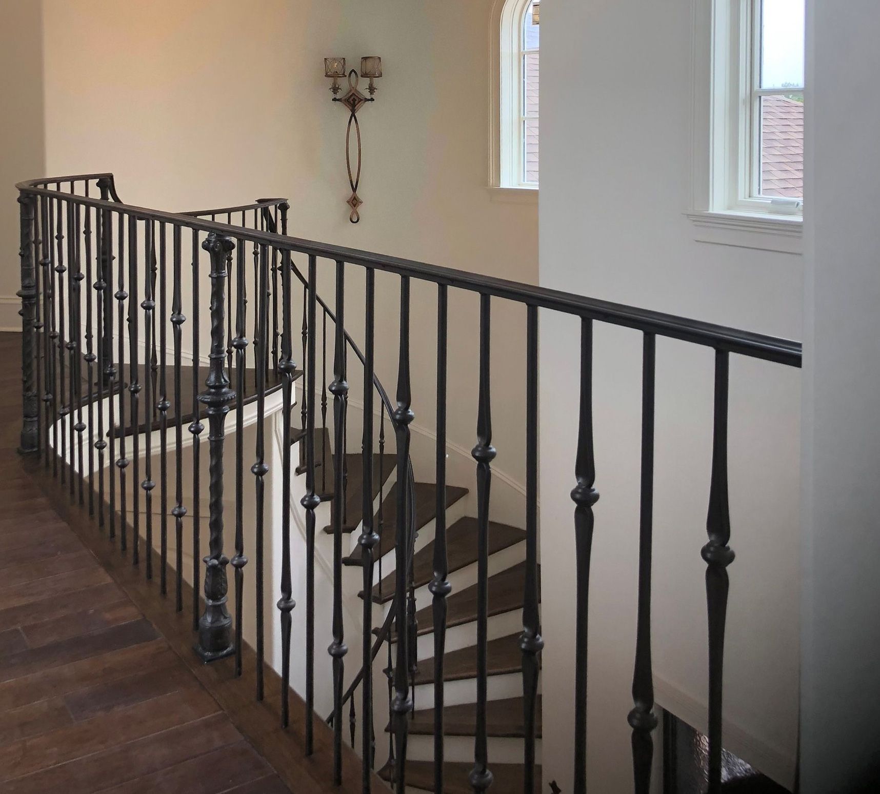 A staircase with a wrought iron railing and a window
